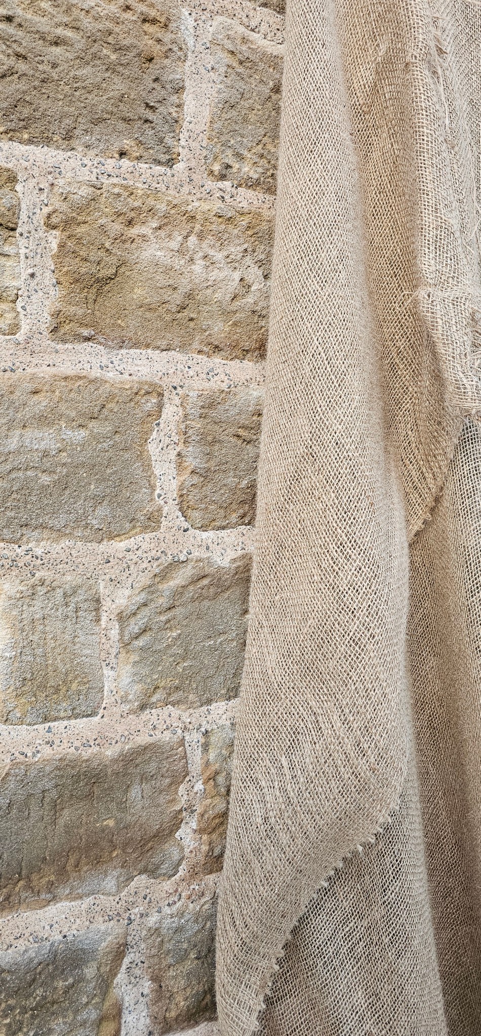 Traditional lime mortar in stone masonry, protected with hessian